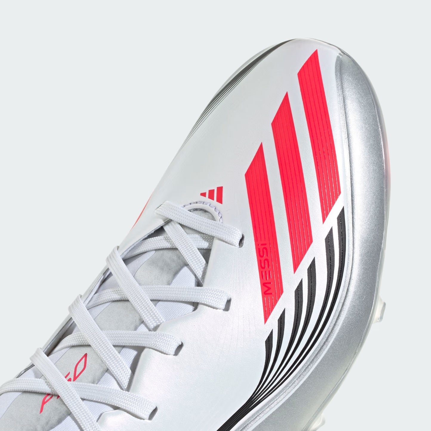 Close-up of a sports shoe with red and black stripes on a light gray background