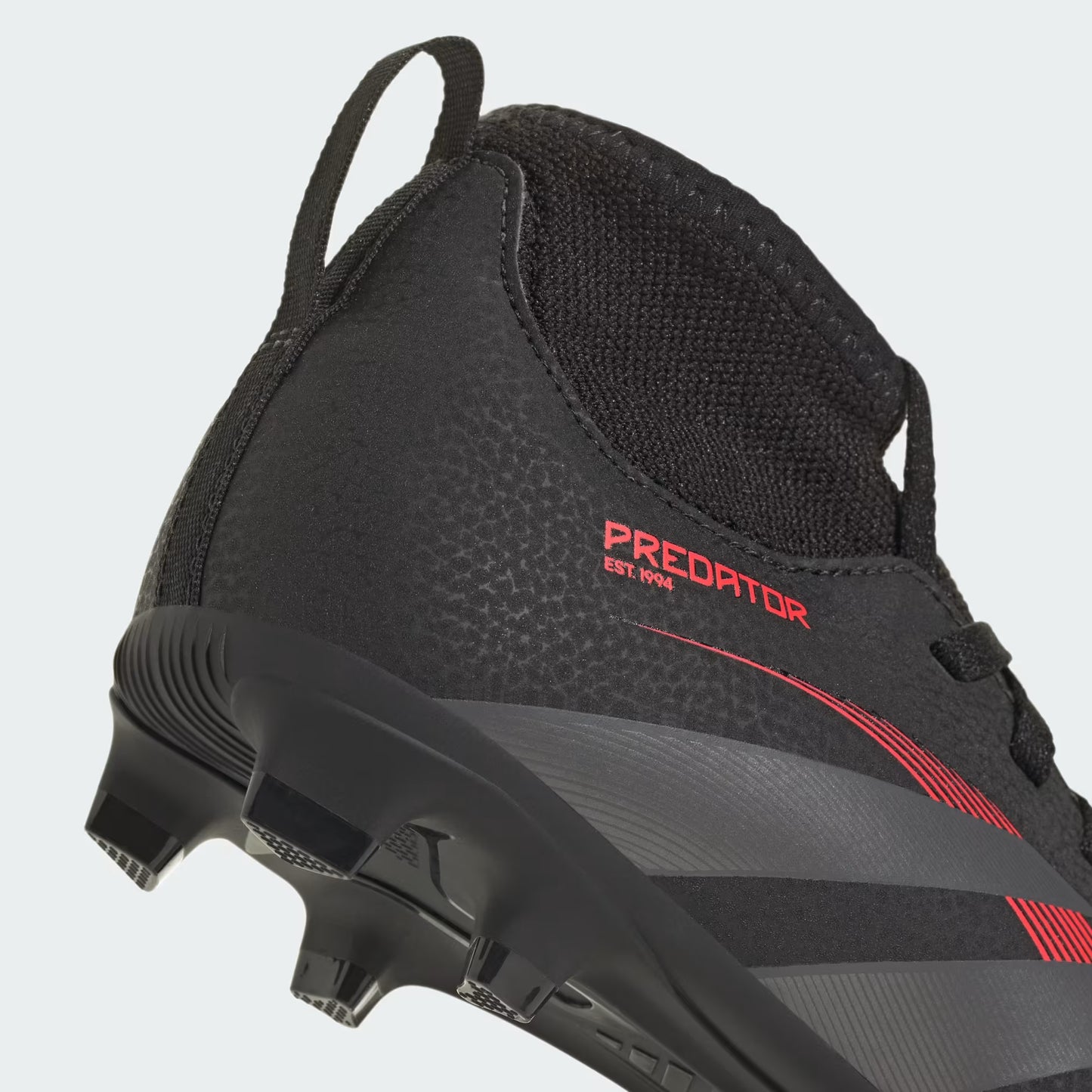 Black and red soccer cleat with 'Predator' branding on a light gray background