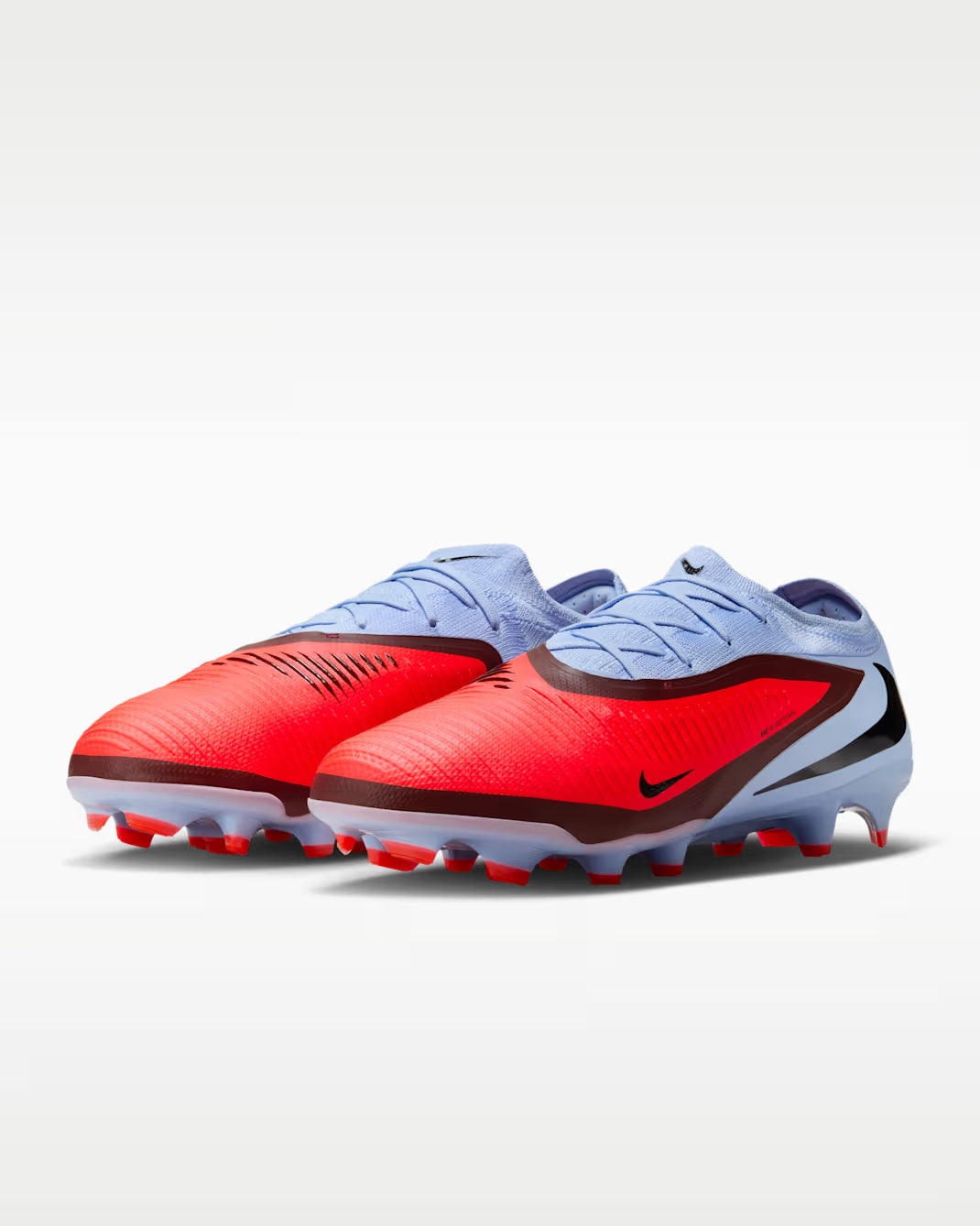 Pair of red and blue soccer cleats on a white background