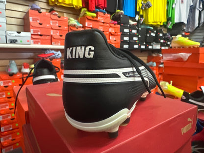 Black sports shoe with 'KING' branding on a red box in a store setting.