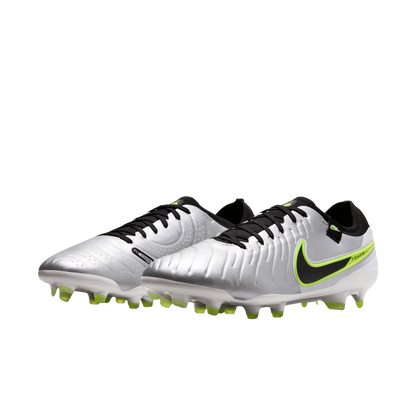 Pair of silver soccer cleats with black and green accents on a white background