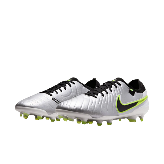 Pair of silver soccer cleats with black and green accents on a white background
