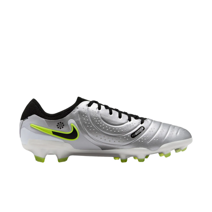 Silver soccer cleat with black and green accents on a white background