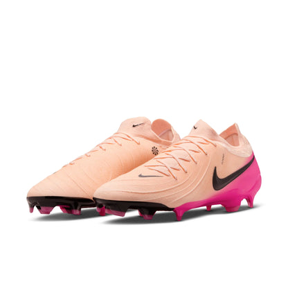 Pair of peach and pink soccer cleats with black Nike logo on a white background