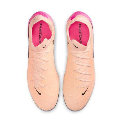 Pair of peach and pink soccer cleats with Nike logo on a white background