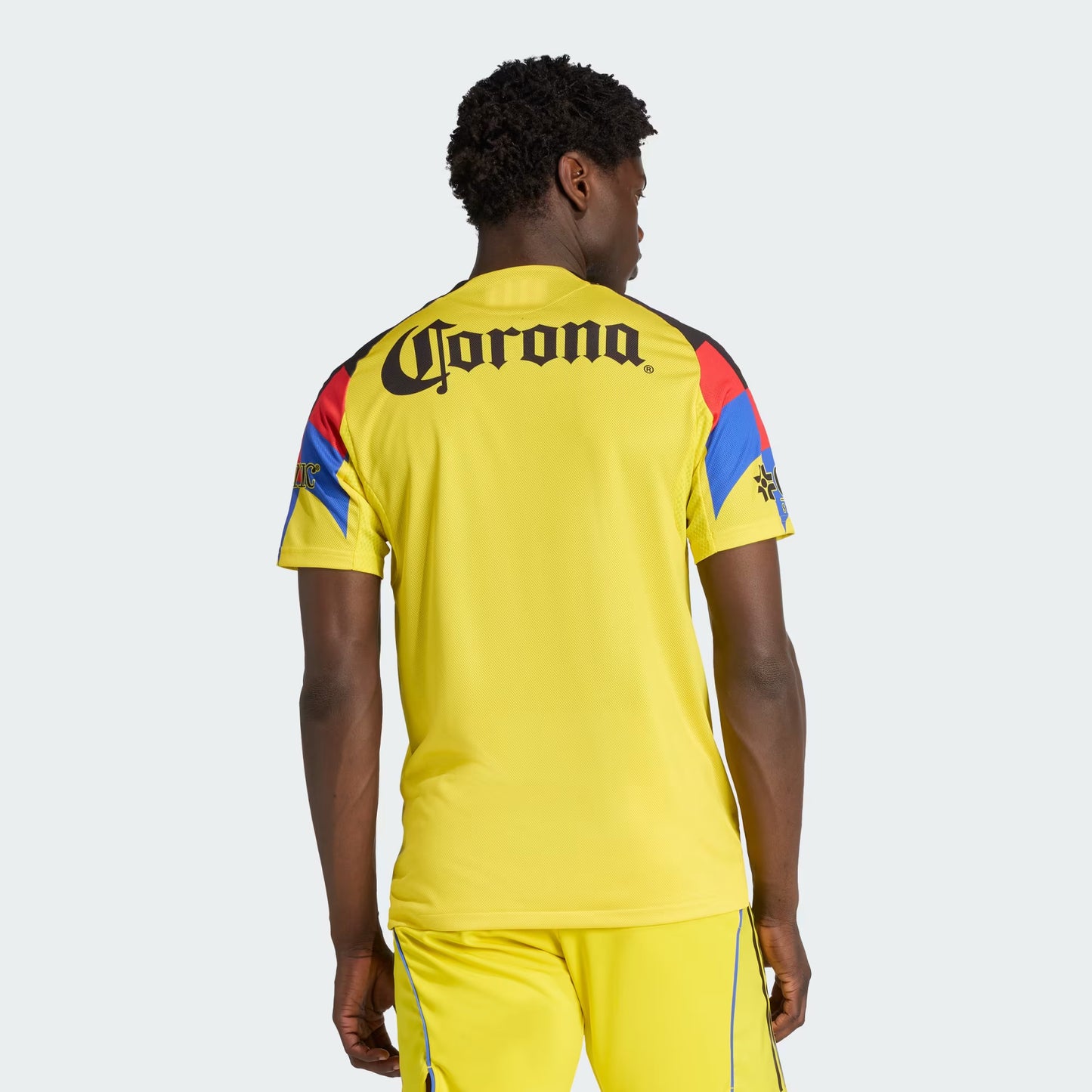 Person wearing a yellow sports outfit with Corona branding on the back.