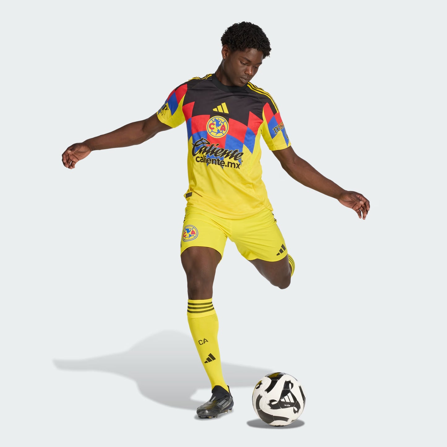 Person wearing a colorful soccer jersey and shorts with a ball on a white background