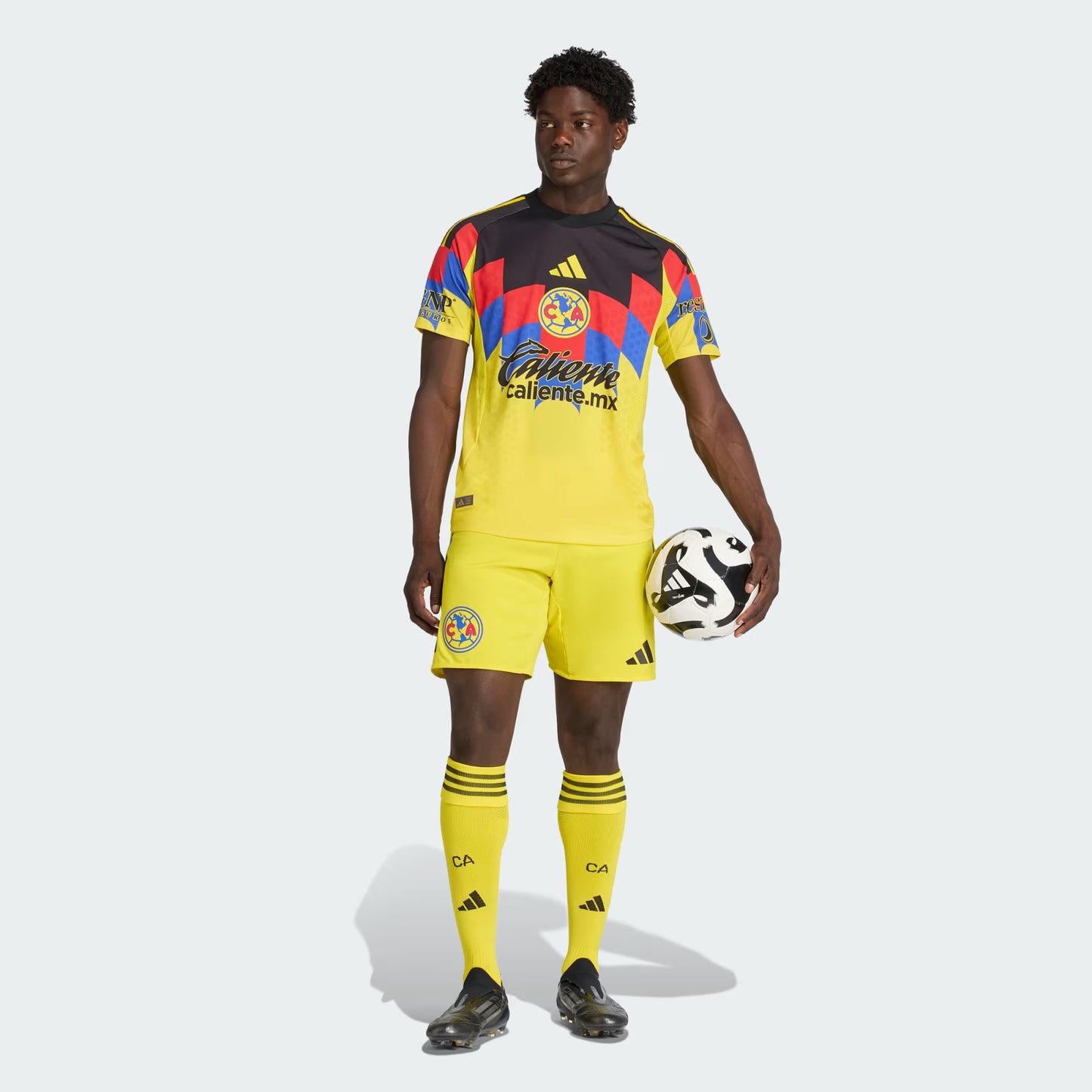 Person wearing a colorful soccer jersey and holding a soccer ball on a white background