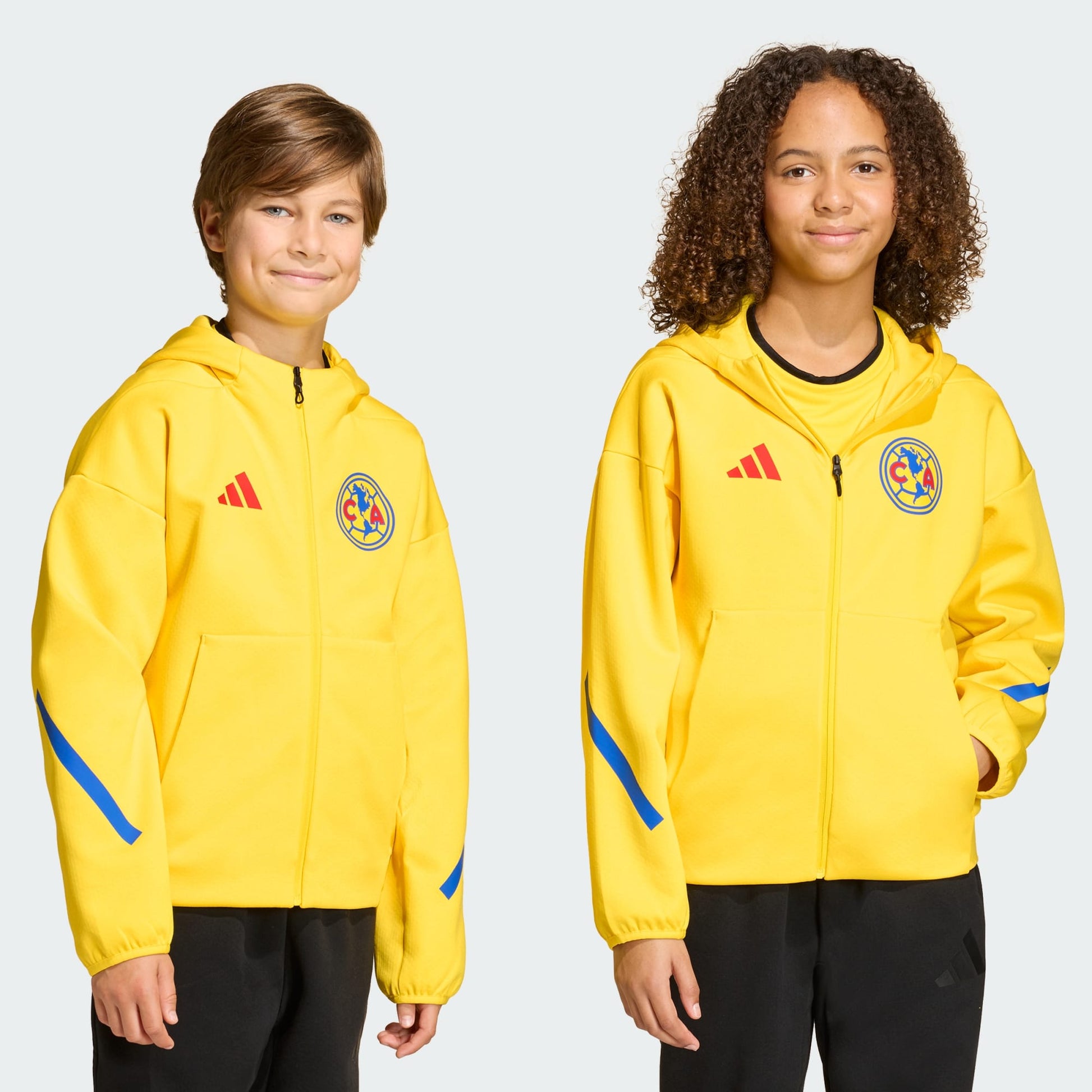 Two children wearing yellow jackets with logos on a plain background
