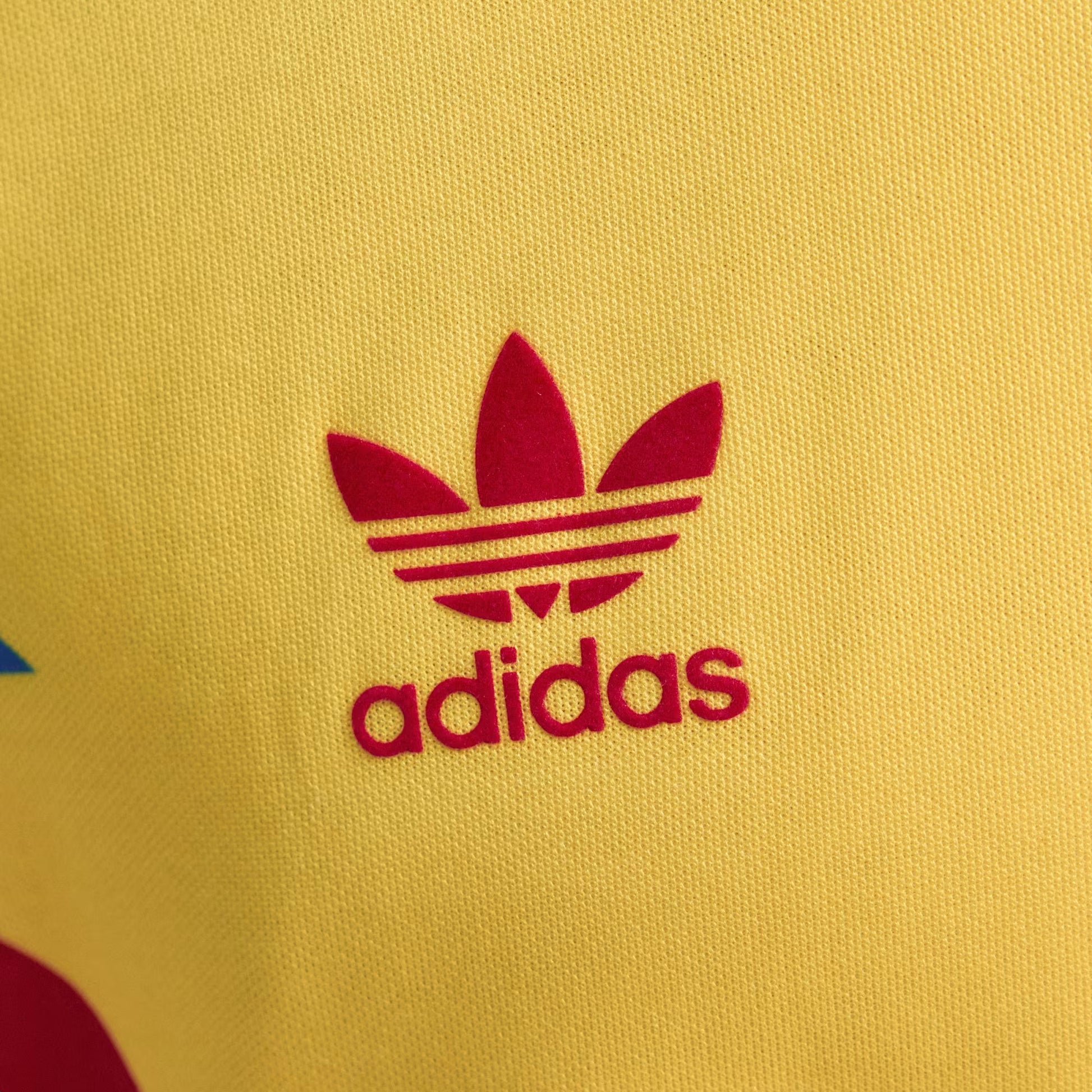 Close-up of Adidas logo on a yellow background