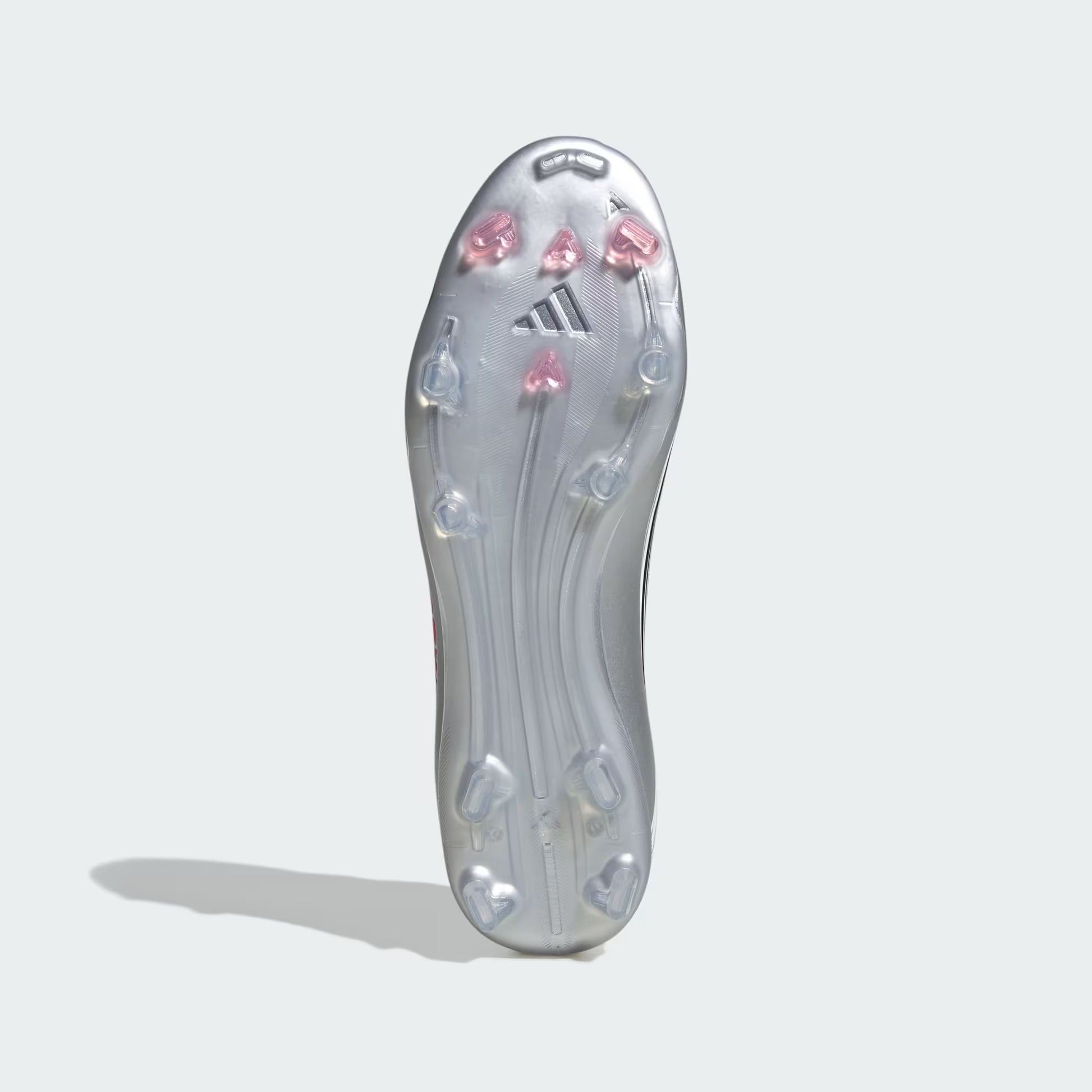 Clear soccer cleat sole with pink and blue studs on a light gray background