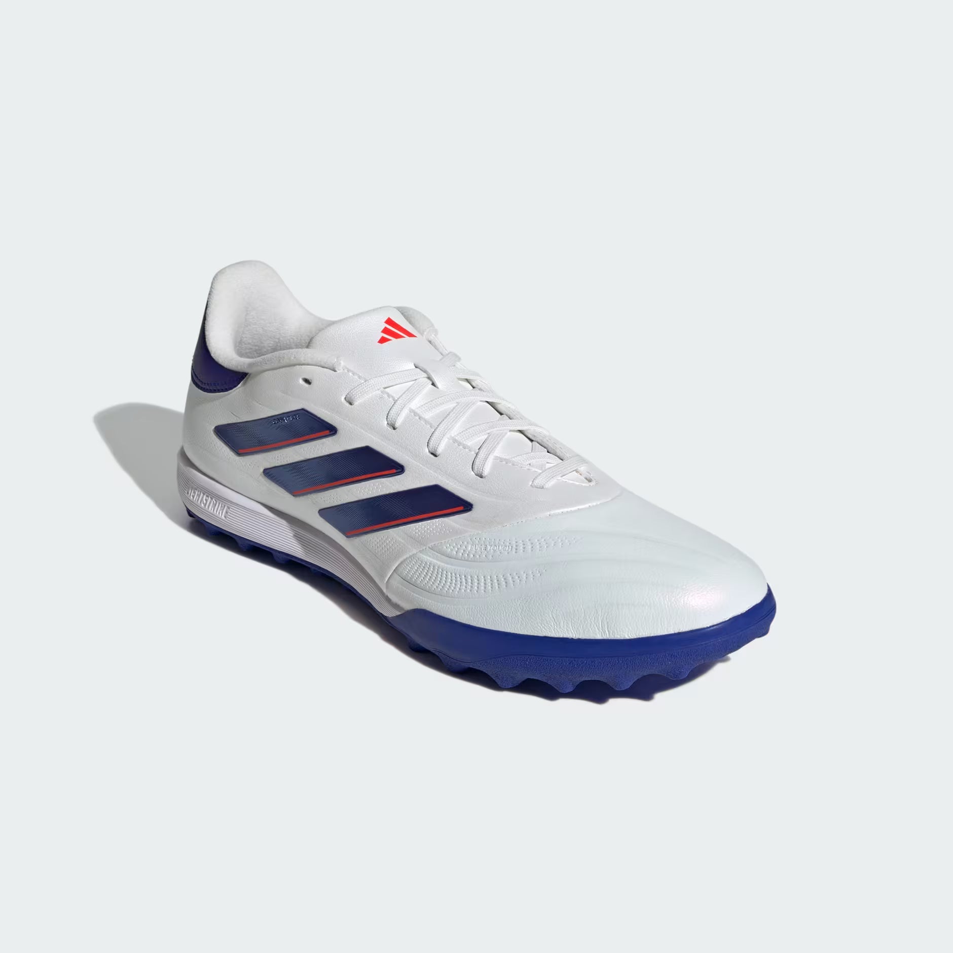 White and blue athletic shoe with red accents on a light gray background