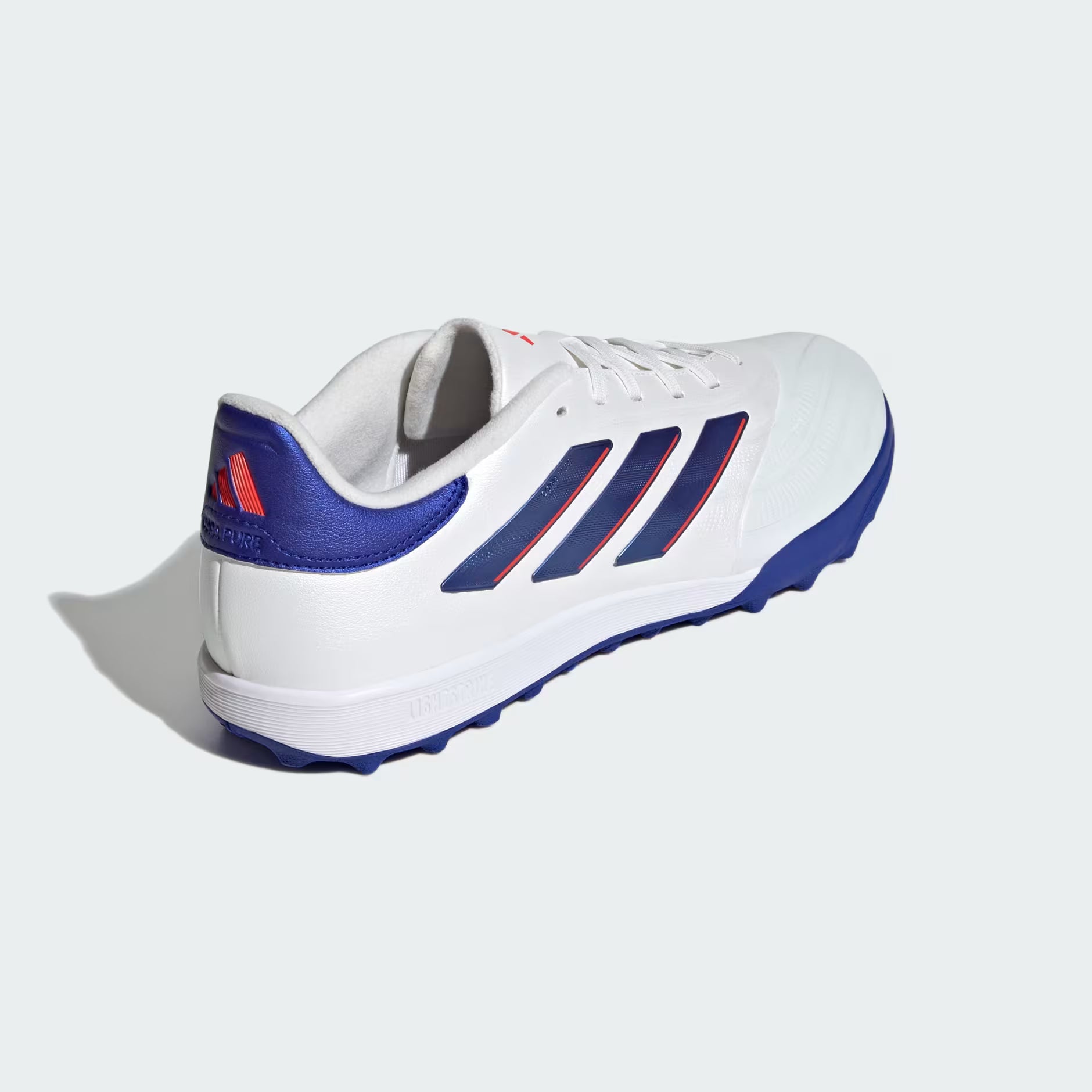 White sports shoe with blue and red accents on a light gray background