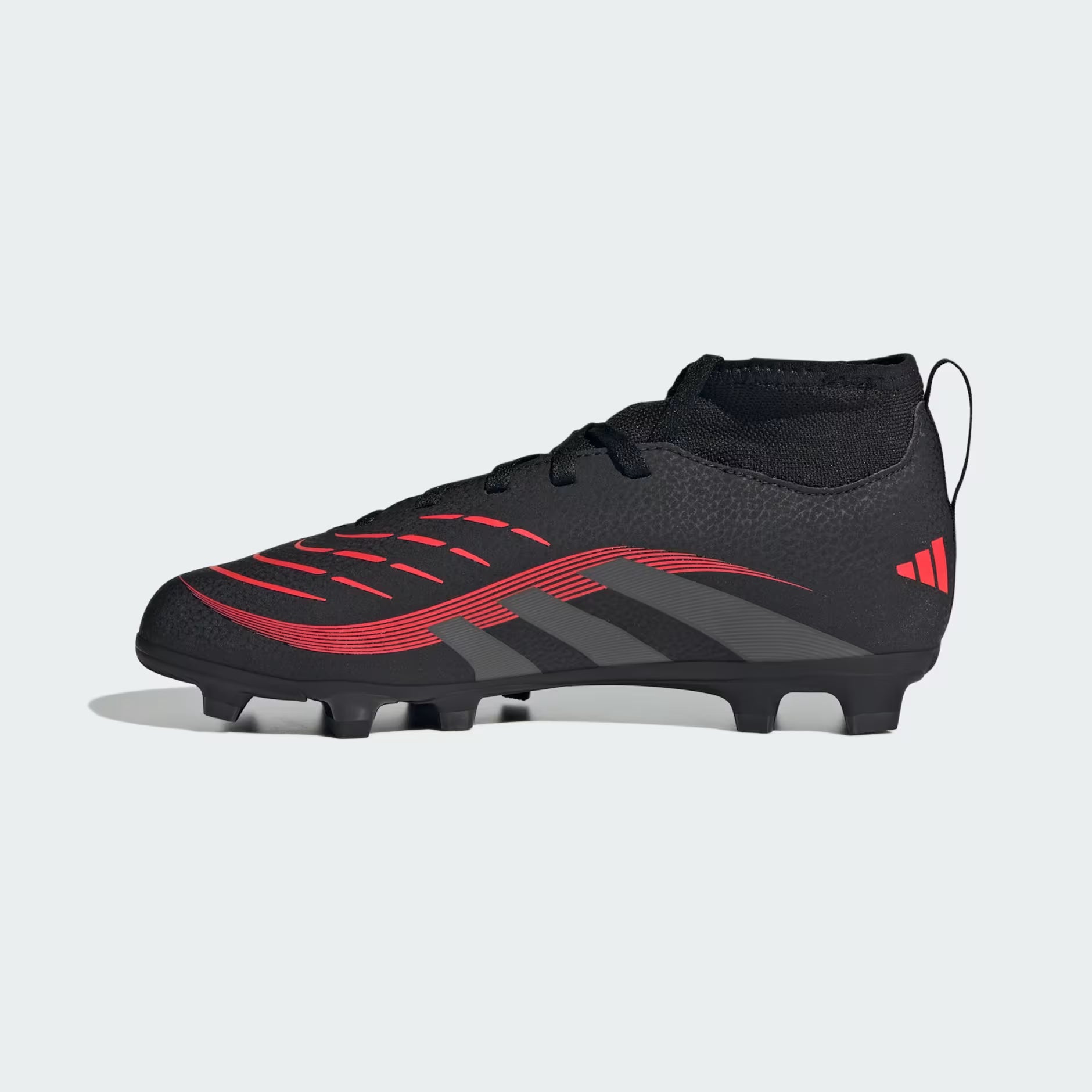 Black and red soccer cleat on a light gray background