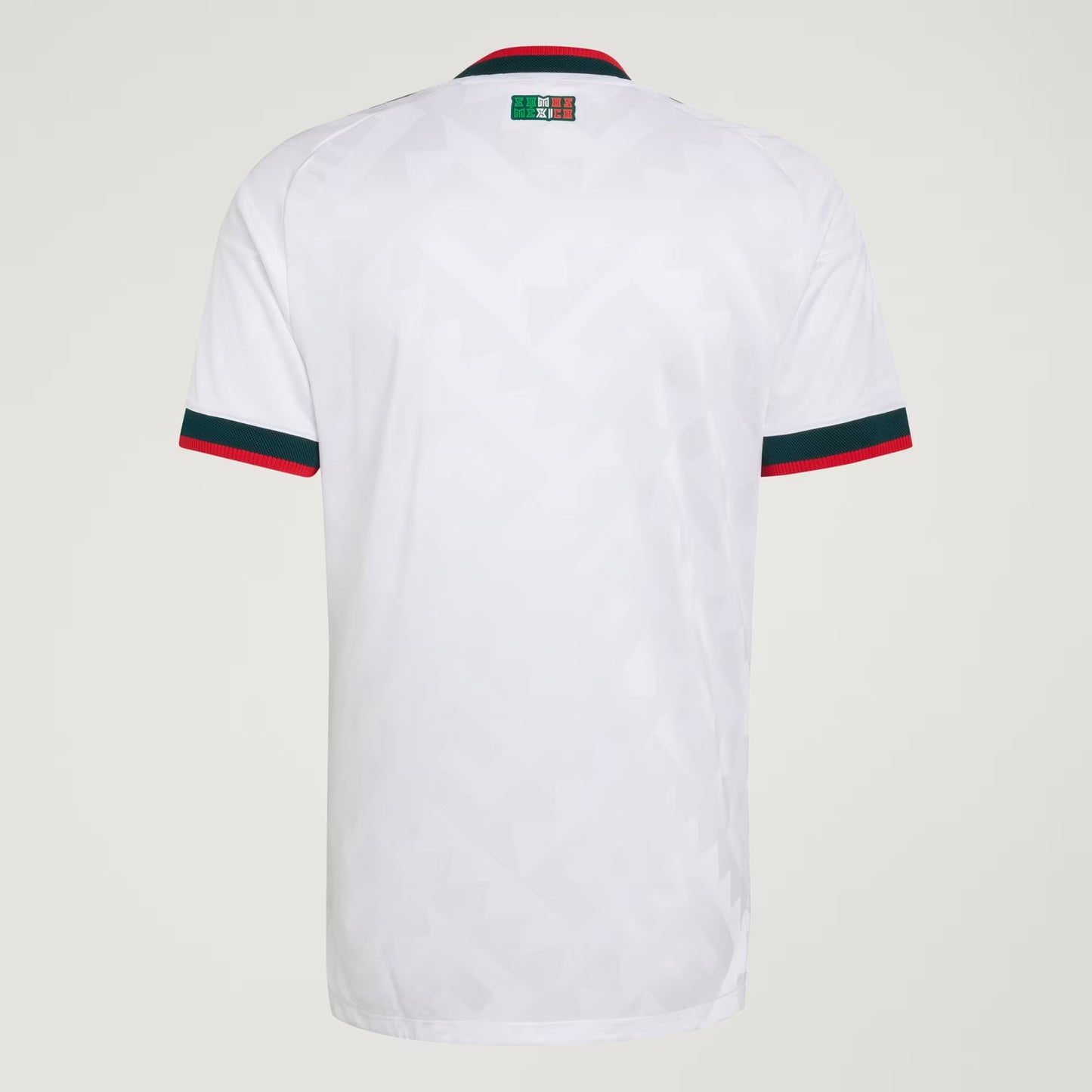 White shirt with green and red accents on a light gray background