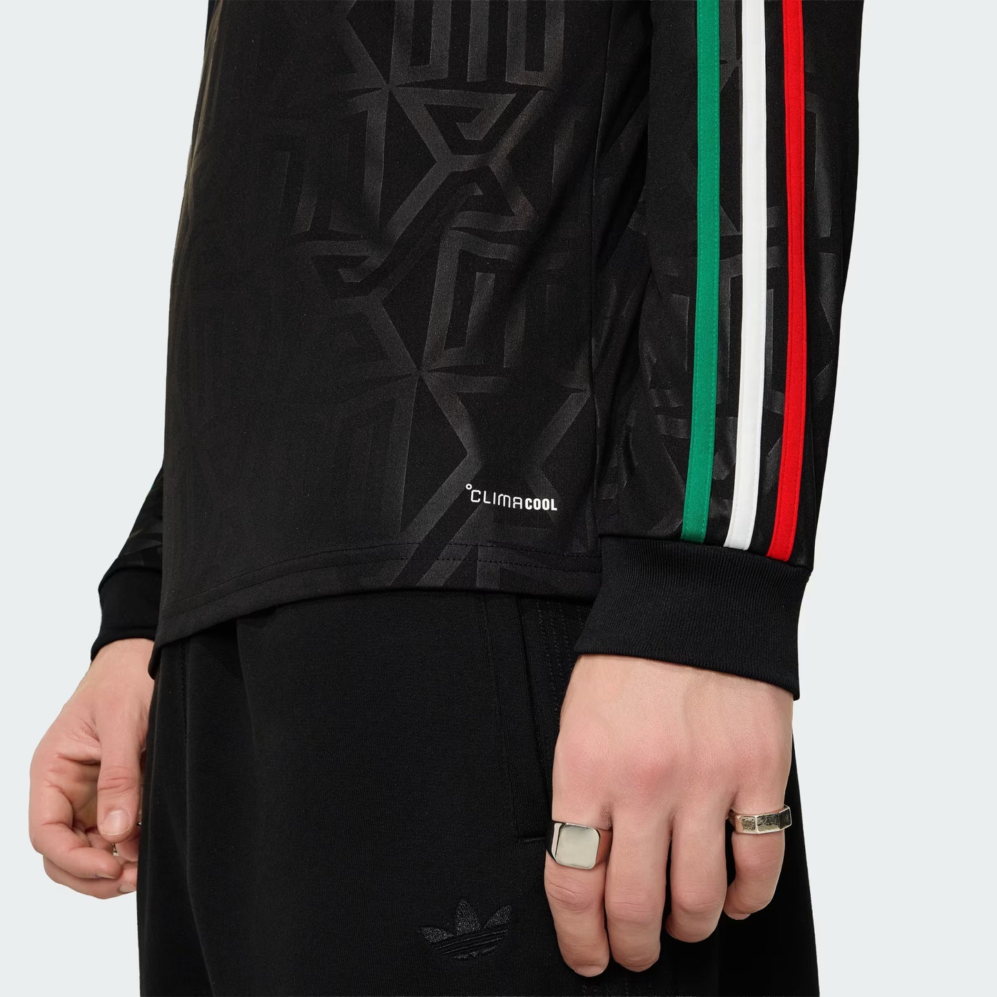 Black athletic jacket with colorful stripes on sleeves against a light gray background