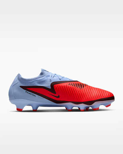 Pair of red and light blue soccer cleats on a white background