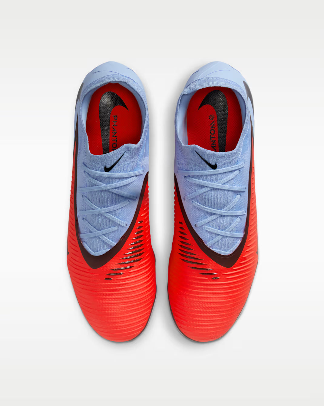 Pair of red and blue soccer cleats with Nike logo on a white background