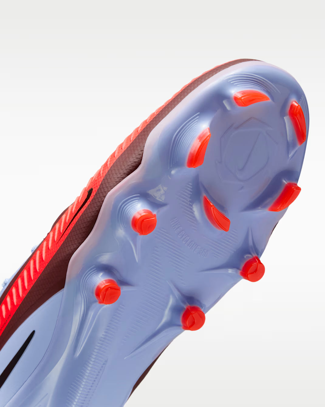 Close-up of a sports shoe sole with red studs on a white background