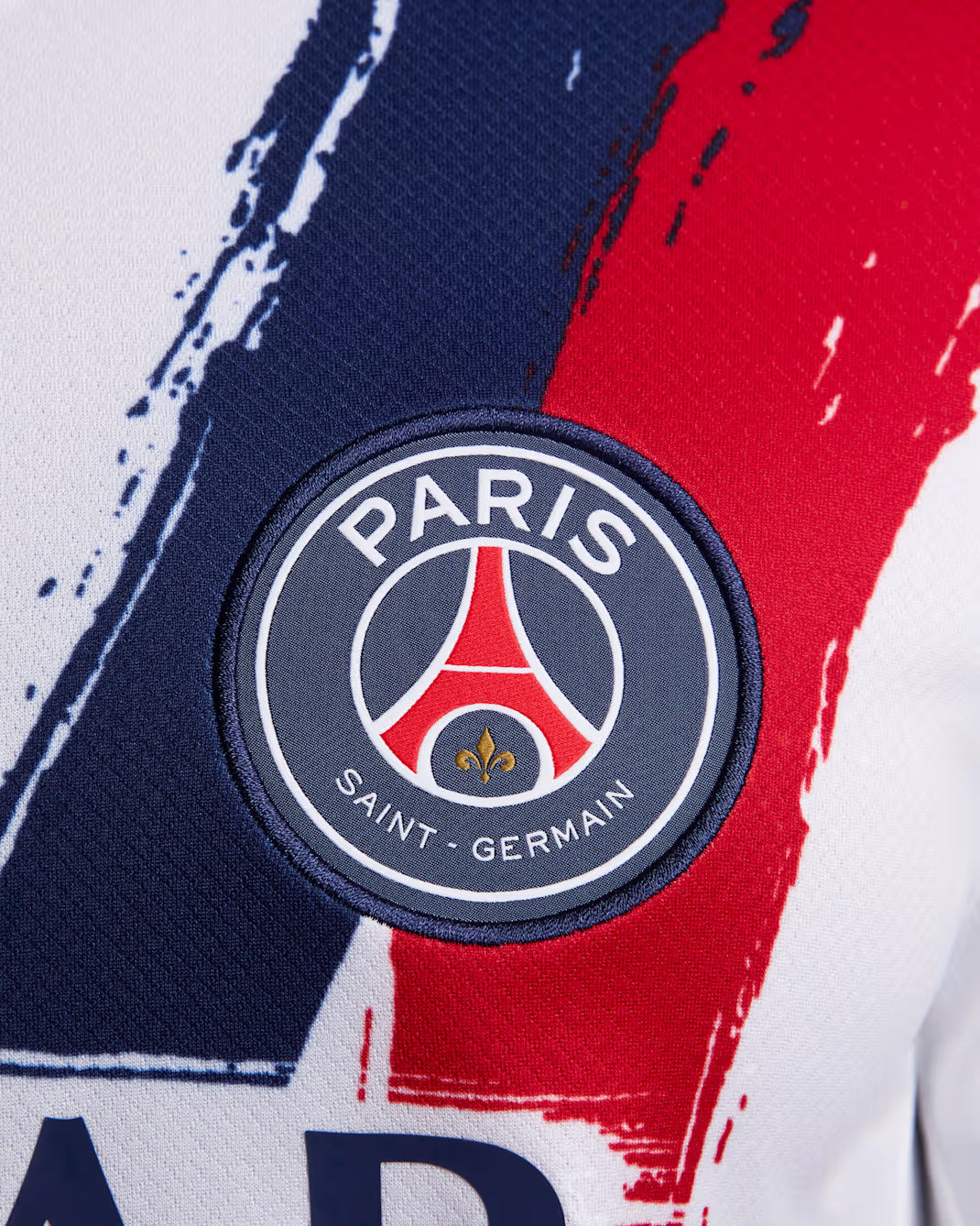 Paris Saint-Germain logo on a sports jersey with red, blue, and white design.