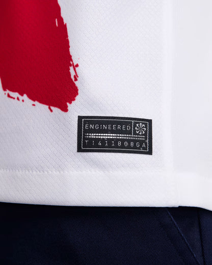 Close-up of a white garment with a red design and a black label on a white background