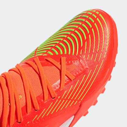 Close-up of a red sports shoe with orange laces on a light gray background