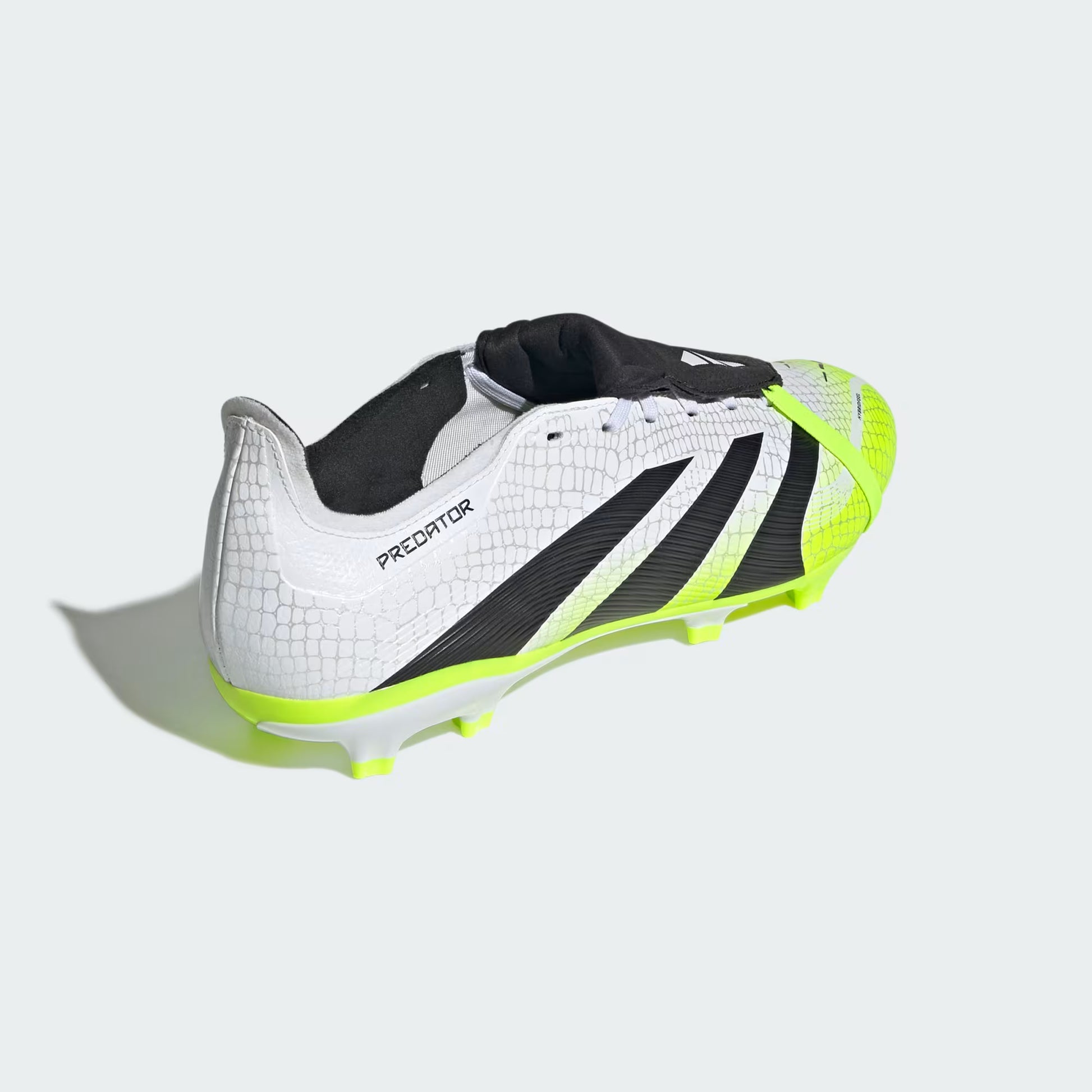White soccer cleat with black and green accents on a light gray background