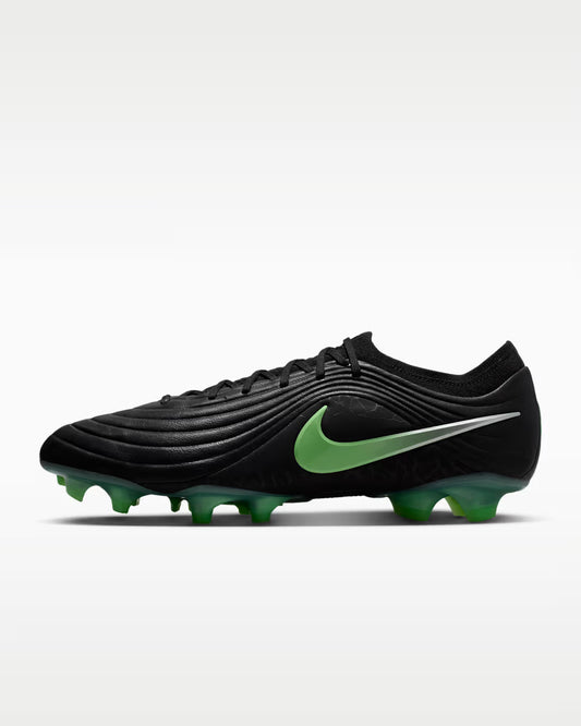 Black soccer cleat with green accents on a white background