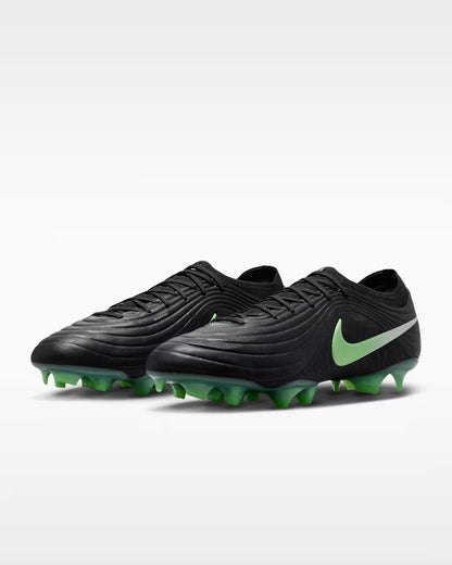 Black soccer cleats with green accents on a white background