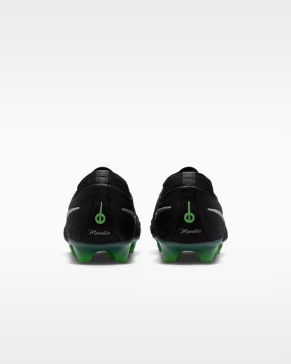 Black soccer cleats with green accents on a white background