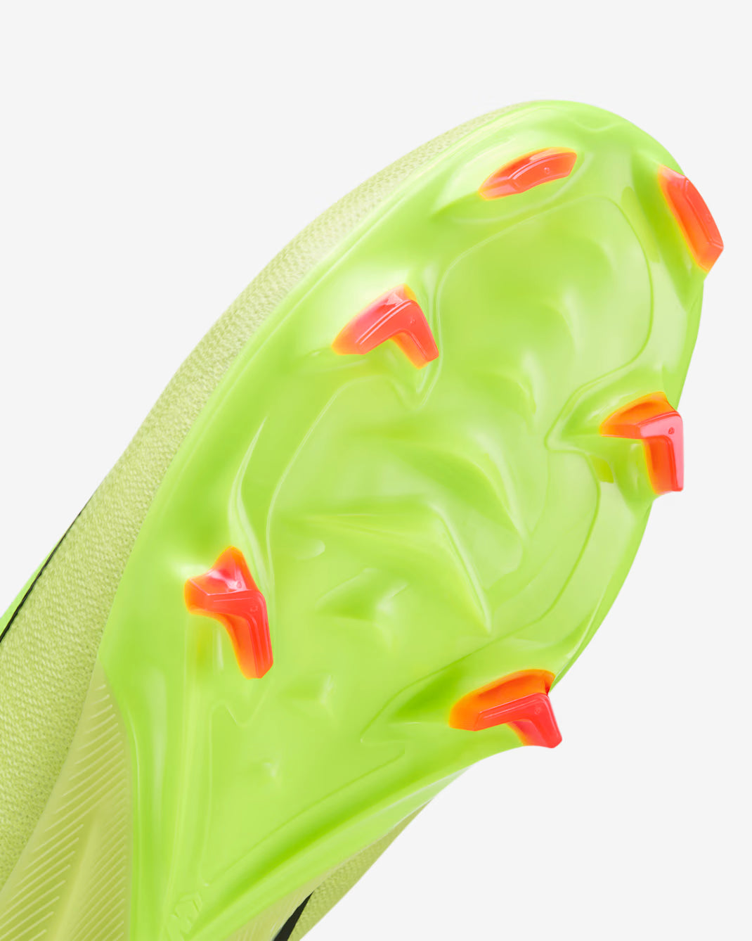 Close-up of a green soccer cleat with red studs on a white background