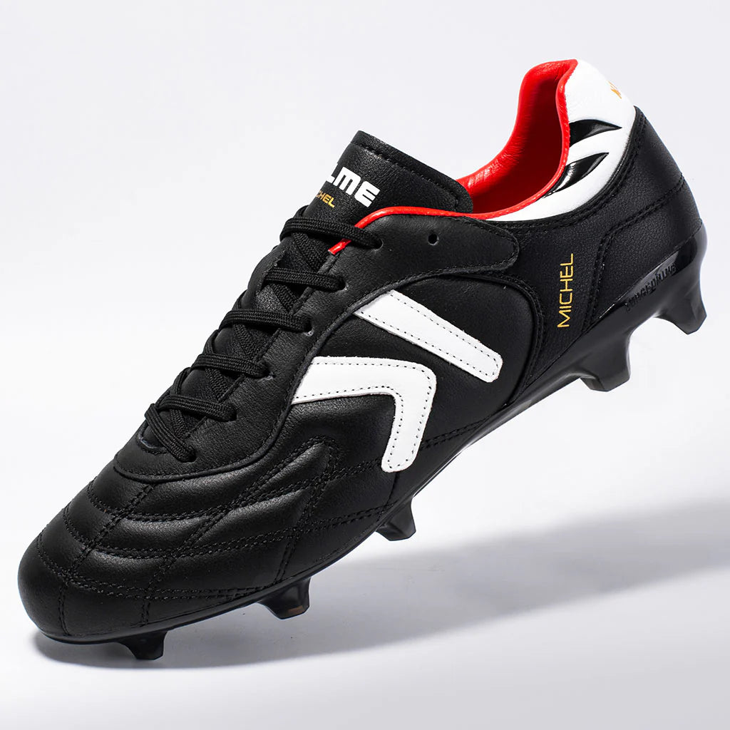 Kelme Black soccer cleat with red and white accents on a light gray background