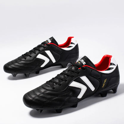 Kelme Black soccer cleats with red and white accents on a light gray background
